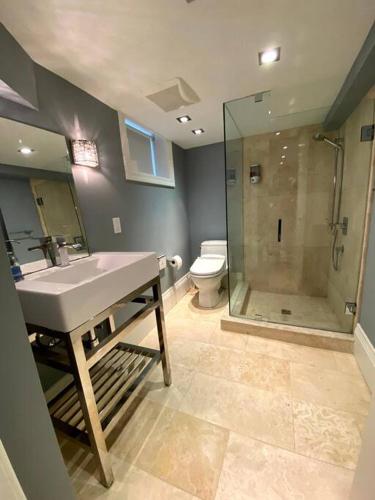 a bathroom with a shower and a sink and a toilet at Leaside Rental with Great Backyard & Pool in Toronto