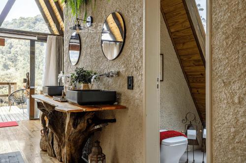a bathroom with two sinks on a stone wall at Chalé Alcântara - Com banheira para casal in São Pedro de Alcântara