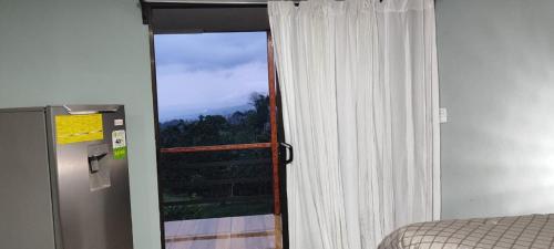 a room with a window and a door with a view at Río Celeste Nature View in Upala