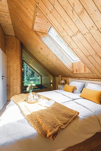 a bedroom with a large white bed with a skylight at Mazury Twin House in Wynki