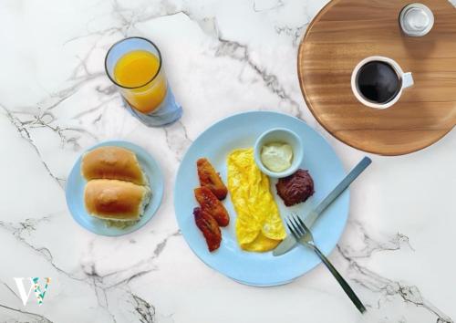 un piatto per la colazione con uova, pancetta e un bicchiere di succo d'arancia di Hotel Windsor Plaza a San Salvador