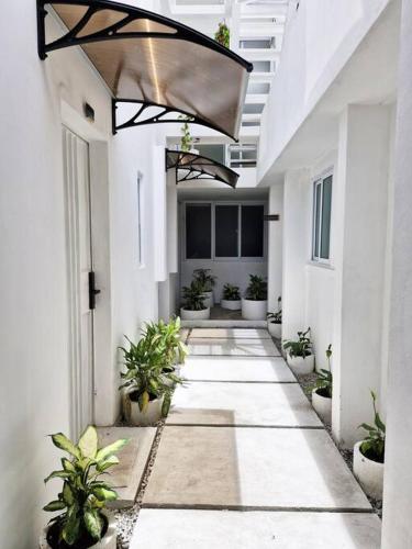a hallway of a white building with potted plants at Moderno y Confortable Apto 4 Familiar Primer Nivel in El Rodeo