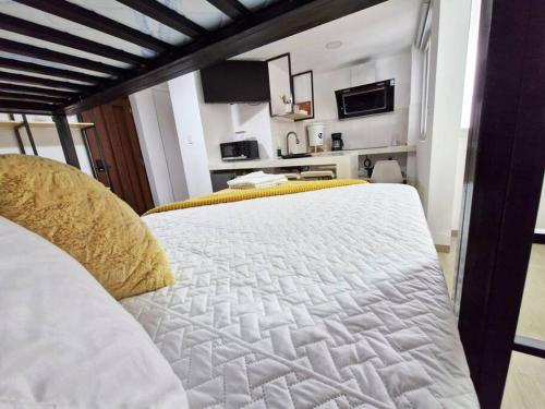 a bedroom with a large white bed with yellow pillows at Moderno y Confortable Apto 4 Familiar Primer Nivel in El Rodeo
