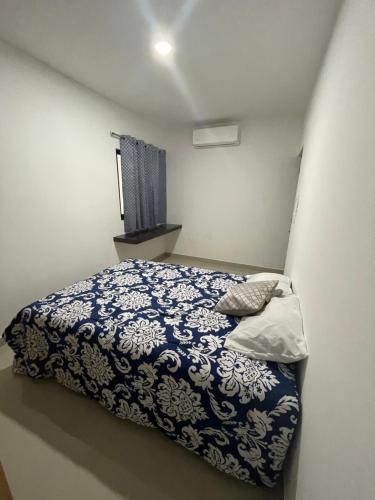 a bedroom with a bed with a blue and white blanket at Torre Loshea in Culiacán