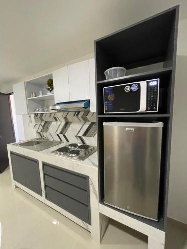 a kitchen with a stove and a microwave at Torre Loshea in Culiacán