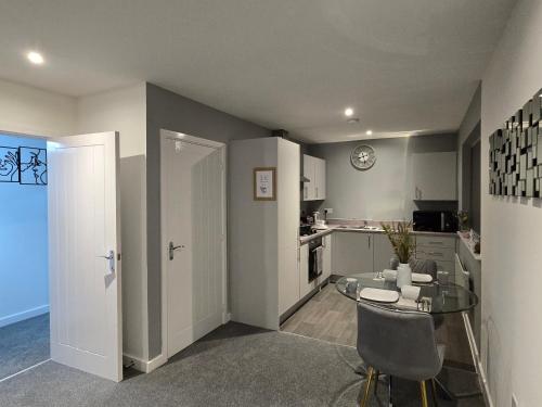 a kitchen with a glass table and a dining room at Well-Preserved 2 Bedroom Flat Apartment Around Ricoh Arena-Coventry City FC in Longford