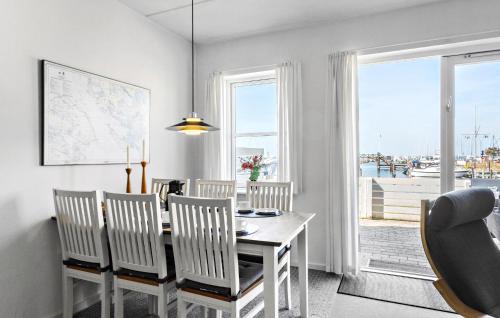 ルーケベングにあるTwo-Bedroom Apartment In Rudkobingのテーブルと椅子と窓のあるダイニングルーム