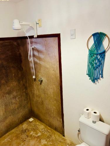a bathroom with a toilet and a basket on the wall at Pousada kaz'oca in Icaraí
