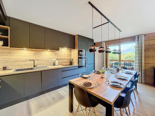 une cuisine avec une grande table en bois et des armoires bleues dans l'établissement Appartement neuf 4 chambres proche Lac Bio, parking, wifi - FR-1-560-108, à Combloux