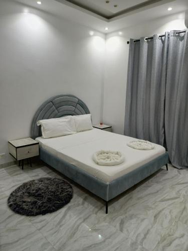 a bedroom with a large bed with a gray headboard at LOCABISS 3-Madina in Rufisque