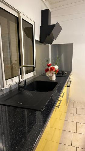 a kitchen with a black counter top with a sink at P'tii repos Soleil in Sainte-Anne