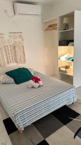 a bedroom with a bed with a blue and white stripes at P'tii repos Soleil in Sainte-Anne