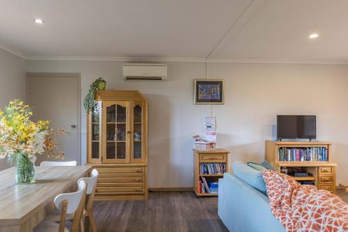 a living room with a blue couch and a table at JoY's Guesthouse in Romsey