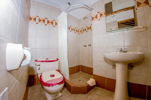 a bathroom with a toilet and a sink at Hostal El Grial in Cusco