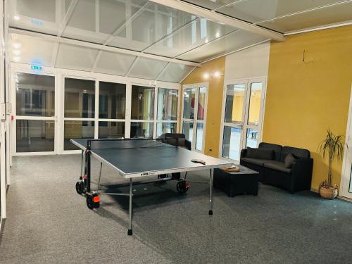 a ping pong table in the middle of a room at DAMA Lodge in La Ferté-Bernard