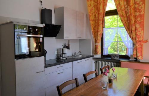 a kitchen with a wooden table and a dining room at Ferienwohnungen am Stadtpalais - Bernkastel in Bernkastel-Kues