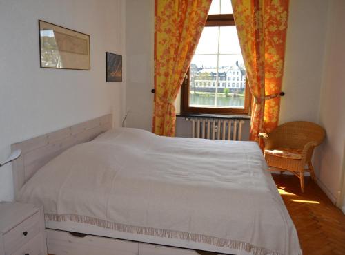 a bedroom with a white bed and a window at Ferienwohnungen am Stadtpalais - Bernkastel in Bernkastel-Kues