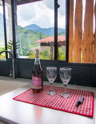 a bottle of wine and two wine glasses on a table at Casa Viva Alojamiento Rural in Jardin