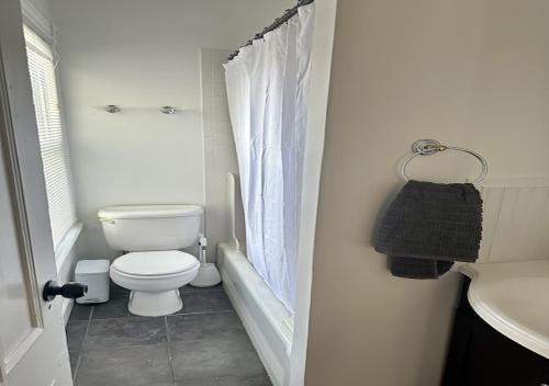 a white bathroom with a toilet and a sink at Sweet Escape, 2BR apt in BEACH community, Only 1 hr to NYC! in Norwalk