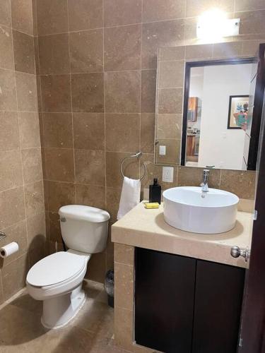 a bathroom with a toilet and a sink at Cozy family house with pool in Puerto Vallarta