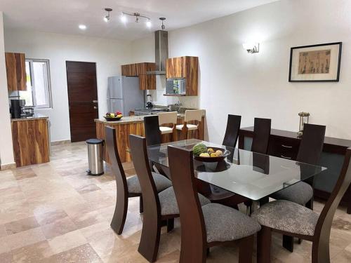 a dining room and kitchen with a table and chairs at Cozy family house with pool in Puerto Vallarta