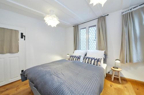 a white bedroom with a bed and a window at Ferienwohnung Badstube Anno 1583 in Bernkastel-Kues