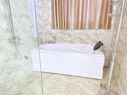 a bathroom with a white bath tub and a shower at HAAP Transit Hotel in Noi Bai