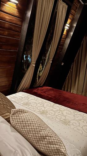 a bedroom with curtains and a bed in a room at Chalé Refúgio da Mata in São José dos Pinhais