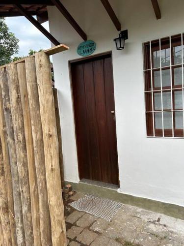 a house with a wooden door and a fence at Casa Pouso dos Colibris em Paraty in Paraty