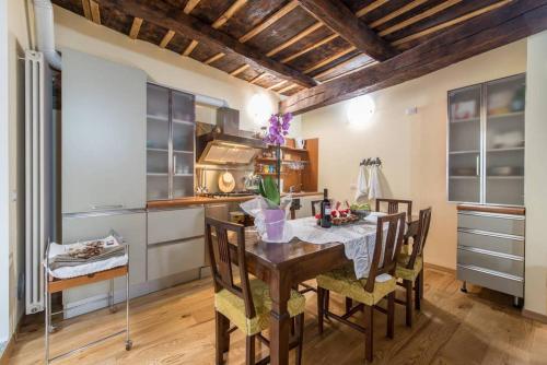 una cucina con tavolo da pranzo e sedie di Porta Dipinta House Bergamo Alta a Bergamo
