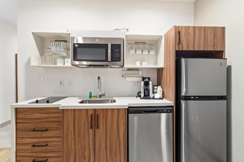 a kitchen with a sink and a refrigerator at Hawthorn Extended Stay by Wyndham Port Arthur in Port Arthur