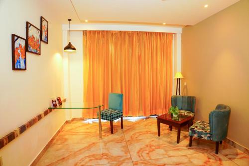a living room with a glass table and chairs at Aachman River and Valley View Resort Dharamshala - A riverside resort with balcony view in Dharamshala