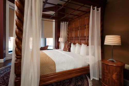um quarto com uma cama grande e um dossel em madeira em Hotel Brexton, Trademark Collection by Wyndham em Baltimore