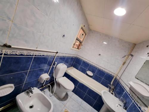 a bathroom with two sinks a toilet and a bath tub at PHENOMENAL SEA VIEW in Abu Dhabi