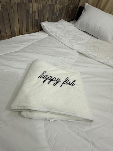 a white bed with a happy pillows on it at PHENOMENAL SEA VIEW in Abu Dhabi