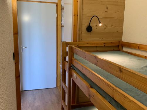 Cette chambre comprend 2 lits superposés et une porte. dans l'établissement Charmant appart 2P cabine, rénové, balcon, parking gratuit, pied des pistes - FR-1-755-22, à Aime La Plagne