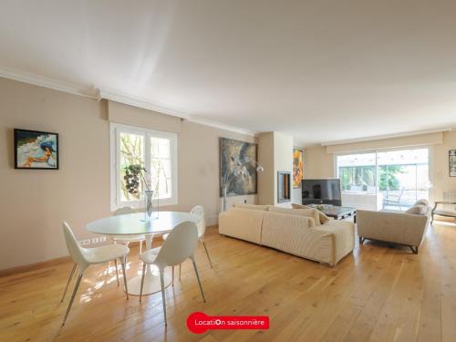un salon avec une table et un canapé dans l'établissement Grande Maison 5 chambres avec Piscine à Lagord, Cap. 10 Pers - FR-1-535-60, à Lagord