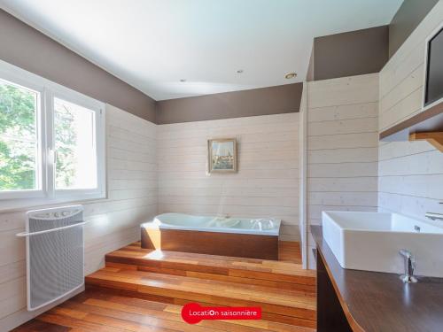 une salle de bain avec une baignoire et un lavabo dans l'établissement Grande Maison 5 chambres avec Piscine à Lagord, Cap. 10 Pers - FR-1-535-60, à Lagord