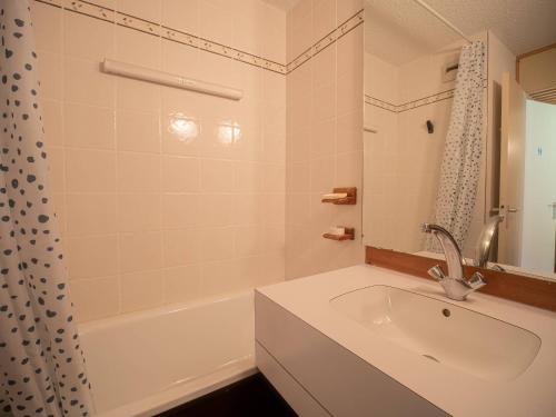 La salle de bains blanche est pourvue d'un lavabo et d'une baignoire. dans l'établissement Studio cosy à Valmorel, 100m des remontées, animaux admis - FR-1-356-444, à Valmorel
