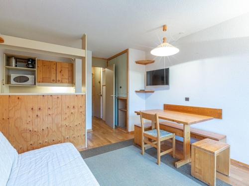 une cuisine et une salle à manger avec une table et des chaises en bois dans l'établissement Valmorel: 2 Pièces, Balcon Sud, Proche Pistes et Remontées - FR-1-356-485, à Valmorel