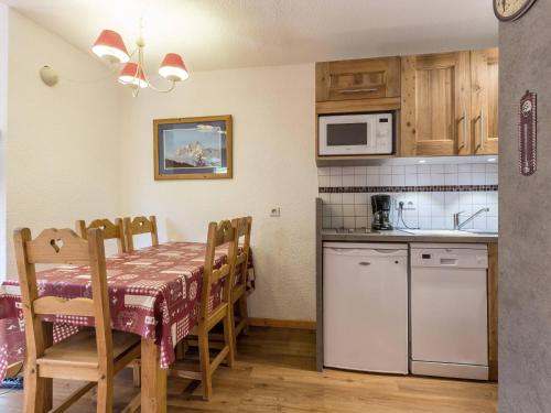 une cuisine et une salle à manger avec une table et des chaises dans l'établissement Appartement à proximité des pistes avec cuisine équipée, terrasse exposée SUD-OUEST - FR-1-356-447, à Valmorel