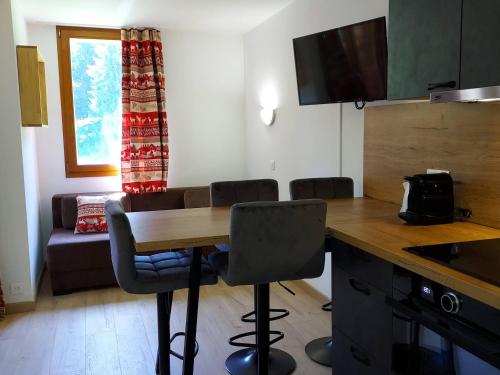 une cuisine avec une table et des chaises dans une pièce dans l'établissement Studio cosy 4 pers., balcon, à 80m des pistes, animaux acceptés, parking - FR-1-356-466, à Valmorel