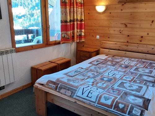 une chambre avec un lit dans une cabane en bois dans l'établissement Studio divisible, près des pistes, animaux admis - FR-1-356-476, à Valmorel