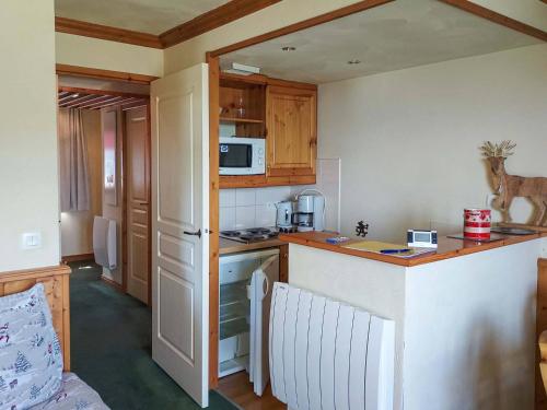une petite cuisine avec un comptoir et un micro-ondes dans l'établissement Appartement cosy 1 chambre à Valmorel, proche remontées et centre, avec balcon - FR-1-356-487, à Valmorel
