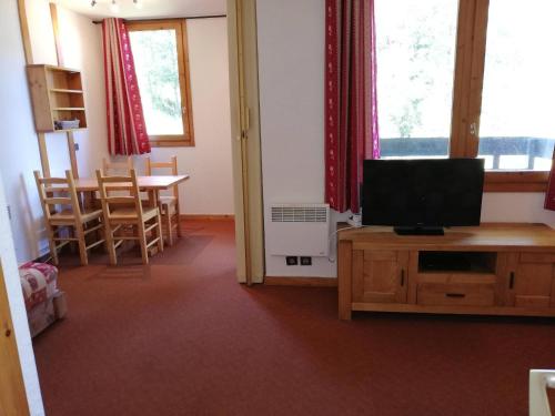 - un salon avec une télévision et une table à manger dans l'établissement Studio divisible 27m², balcon, proche pistes et remontées - FR-1-356-481, à Valmorel