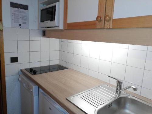 un comptoir de cuisine avec un évier et un micro-ondes dans l'établissement Studio divisible 27m², balcon, proche pistes et remontées - FR-1-356-481, à Valmorel