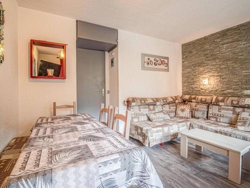 une chambre avec un lit et un canapé dans l'établissement Valmorel - Appartement 2 pièces avec balcon, accès pistes et animaux admis - FR-1-356-494, à Valmorel