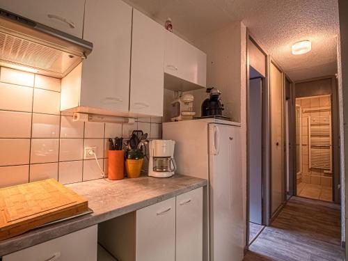 une cuisine avec des armoires blanches et un réfrigérateur blanc dans l'établissement Valmorel - Appartement 2 pièces avec balcon, accès pistes et animaux admis - FR-1-356-494, à Valmorel
