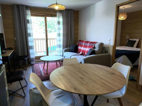 un salon avec une table et un canapé dans l'établissement Appartement cosy 4* pied de pistes avec balcon et parking à Valmorel - FR-1-356-502, à Valmorel