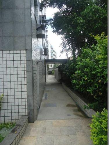 a walkway leading up to a building with trees and bushes at Apartamento aconchegante a 1 km da principal praia de Cabo Frio in Škorak